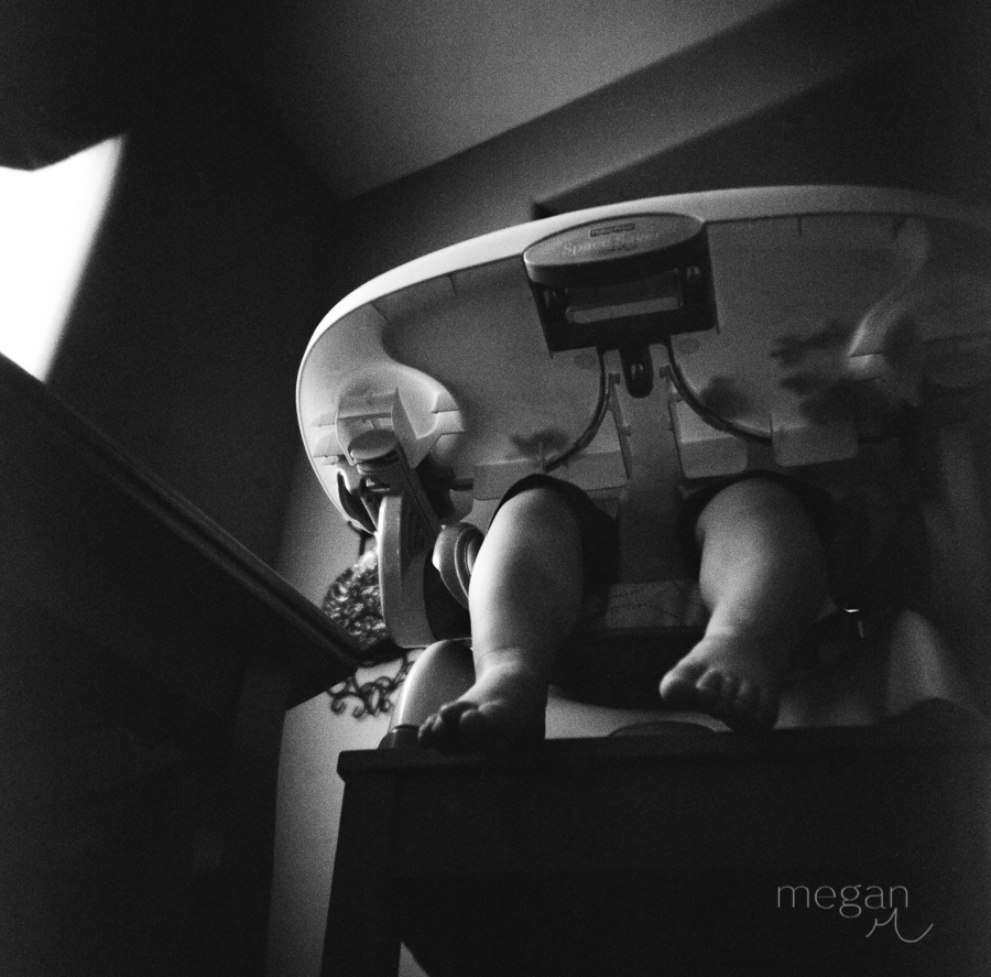Film image of child in highchair shot from below in Black and White