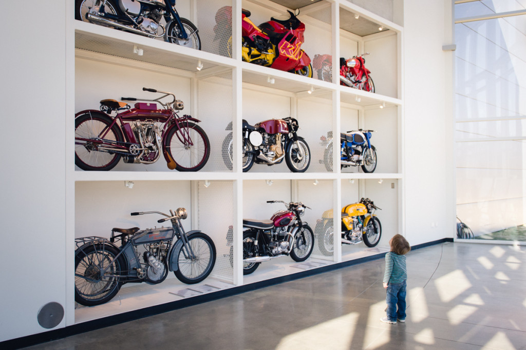 toddler looking at motorcycles on a wall by megan cieloha